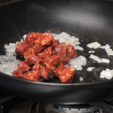 Acitronar la cebolla picada en una sartén con poco de aceite de oliva dos minutos hasta que se torne transparente. Agregar el chorizo y cocer dos minuto más hasta que se vea cocido peor no quemado.