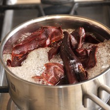 Para preparar el adobo, retirar el rabo de los chiles guajillo con una tijera, abrir por la mitad y retirar las semillas y las venas. Poner a hervir la piel de los chiles durante 5 minutos. Apagar el fuego y dejar reposar 5 minutos más.