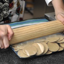 Para prepara la base, colocar las galletas de canela o Marías en una bolsa de plástico resellable y aplanar con el rodillo hasta que queden bien molidas.