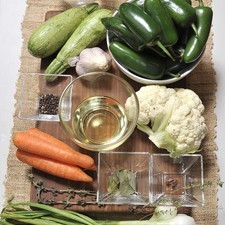Ingredientes: 1/4 taza de Aceite de canola 1 1/2 tazas de Vinagre blanco 1 vara de Tomillo fresco 3 piezas de Zanahoria 1/2 cucharita de Pimienta negra entera Sal 4 piezas de Hoja de laurel 2 piezas de Calabacita 2 piezas de Clavo de olor 1 trozo de Coliflor 1/2 taza de Agua 8 piezas de Cebollitas de cambray 1 vara de Mejorana 1 cabeza de Ajo 10 piezas de Chile jalapeño