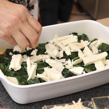 Sobre ellas una capa de espinacas, después otra de salsa, luego queso mozzarella desmenuzado.