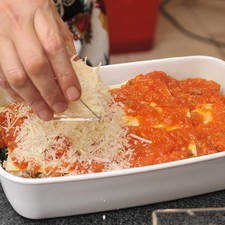 Repetir la misma operación hasta cubrir todo el molde. Espolvorear con queso parmesano encima y meter al horno a 350°F (150°C) durante 15 minutos.