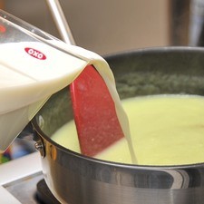 Añadir la leche y continuar meneando rápidamente. Al soltar el hervor, bajar la lumbre y dejar hervir durante 5 minutos, mover con frecuencia.