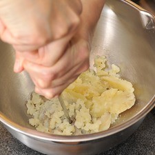 Para preparar la masa, poner a cocer la papa en agua hirviendo de 15 a 20 minutos. Dejar que se enfríe. Pelar y moler con el machacador de papas.