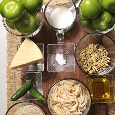 ½ taza de ajonjolí 1/3 de taza de pepita de calabaza 15 tomates verdes 2 chiles serranos Aceite vegetal al gusto ½ taza de crema de leche de vaca Sal al gusto 1 pizca bicarbonato de sodio 12 tortillas 1 ½ taza de pollo cocido y desmenuzado 150 gramos de queso manchego, rallado