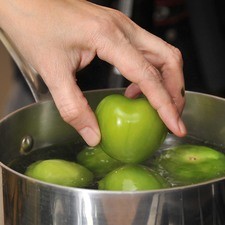 Poner a hervir los tomates verdes junto con los chiles serranos durante cinco minutos hasta que cambien de color pero antes de que se reviente piel.