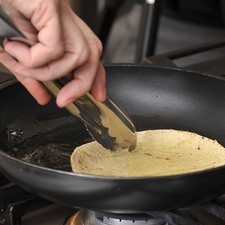 Calentar un poco de aceite en una sartén y pasar rápidamente cada tortilla para que se suavice.