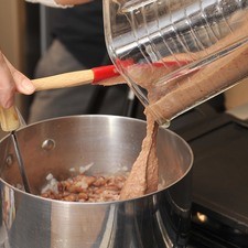 Añadir los frijoles molidos, sazonar con un poco de sal y continuar machacando y cociendo hasta que tengan la consistencia deseada.