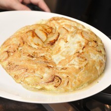 Colocar un plato sobre la sartén, voltearlo con un solo movimiento para que la tortilla quede sobre el plato. Vaciar la tortilla nuevamente sobre la sartén con la parte cruda hacia abajo y continuar cociendo por el otro lado. Es importante dejar el huevo un poco tierno y no cocer de más.