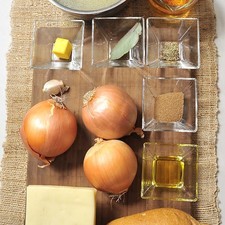 1 cucharada de mantequilla 1 cucharada de aceite de oliva 3 cebollas amarillas ¼ de cucharita de tomillo 1 diente de ajo 1 cucharada de azúcar morena 4 tazas de caldo de res 1 hoja de laurel 1 taza de vino blanco Sal al gusto Pimienta negra molida la gusto 1 pan francés 4 rebanadas de queso gruyere