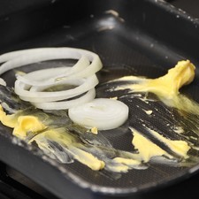 Colocar en una charola para horno mantequilla, aceite, las rodajas de cebolla.