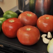 Mientras se cuece le pollo, asar los tomates, los jitomates, los dientes de media cabeza de ajo y la mitad de una cebolla sobre el comal, dando vuelta con una pinza hasta que se vean dorados por todos lados. Reservar.