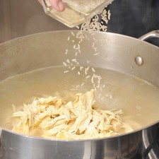 Añadir el pollo deshebrado, el arroz crudo.