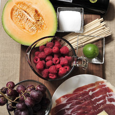 Ingredientes: 1 botella de mas petit pares balta 2 tazas de frambuesa palitos de madera al gusto 1 racimo de uva morada sin semilla 300 gramos de queso manchego 100 gramos de jamón serrano 1/2 pieza de melón 1 pieza de limón 1/4 taza de azúcar blanca