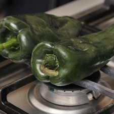 Asar los chiles sobre la hornilla de la estufa, dando vuelta con una pinza hasta que se les formen ampollas por todas partes.