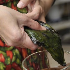 Enjuagar los chiles con la mano mojada con agua para retirar la piel.