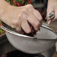 Colar sobre una jarra y exprimir bien la flor dentro del colador. Reservar la flor y el agua de jamaica por separado.