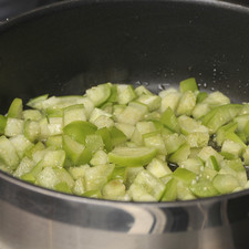 Poner a calentar un poco de aceite en una sartén grande con tapa. Acitronar el ajo picado durante un minuto. Agregar el tomatillo picado y continuar cociendo sin dejar de menear durante 5 minutos hasta que se vea cocido.