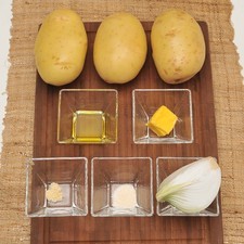 3 papas ½ cucharadita de sal de ajo 1/8 de cucharadita de pimienta blanca molida 2 cucharadas de mantequilla 1 cucharada de aceite de oliva ¼ de cebolla blanca