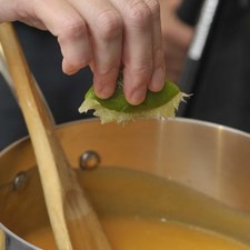 Añadir el jugo de limón sin dejar de menear con una cuchara de madera durante aproximadamente 30 minutos hasta que se pueda ver el fondo de la olla al pasar la cuchara.