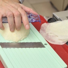 Pelar la jícama, rebanar muy delgada utilizando una mandolina o un rebanador de carnes frías.