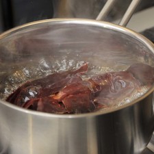 Abrir los chiles guajillos con una tijera, retirarles el rabo, las semillas y las venas. Hervir 5 minutos en una olla honda con agua, dejar reposar 5 minutos más.