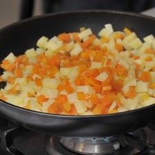 Dorar un poco las papas y las zanahorias en un sartén con aceite y un poco de la salsa de chile. Reservar.