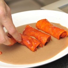 Colocar la salsa de frijol sobre un plato a modo de cama. Poner encima 4 enchiladitas.