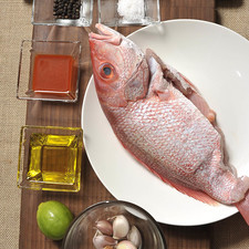 1 cabeza de ajo ¼ de taza de aceite de oliva 1 huachinango 1 limón 1 cucharita pimienta negra entera 1 cucharita de sal de mar Salsa Huichol Papel aluminio Nota: Esta receta se prepara tradicionalmente al carbón utilizando un zarandeador. En esta variante lo hacemos sobre el comal. Algunas personas agregan salsa de soya y otras no usan la salsa Huichol. Todas las variantes son sabrosas.