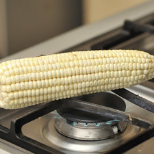 Mientras se cuecen los chayotes, poner a dorar el elote sobre la hornilla de la estufa, dando vuelta con una pinza hasta que se vea dorado por todas partes.