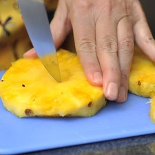Retirar el centro fibroso de las rebanadas de piña utilizando un vaso tequilero.