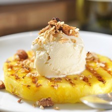 Colocar cada rebanada de piña en un plato, agregar una bola de helado y espolvorear con dos cucharadas de granola. Servir como postre.