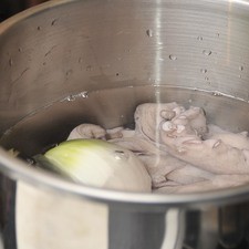 El pulpo debe haber sido congelado y después descongelado para que se le rompan las fibras y se suavice, debe estar limpio (sin ojo ni vísceras) y pesar más o menos 1.5 kg. Una vez descongelado, colocar en la olla exprés con suficiente agua, la cebolla y las hojas de laurel. Tapar la olla y sellar en la velocidad más fuerte. Poner a calentar a fuego alto, Cuando comience a silbar, bajar la lumbre y cocer 30 minutos más. Retirar del fuego y dejar enfriar completamente antes de desfogar la válvula.