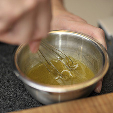 Preparar un aderezo mezclando el aceite de oliva, el vinagre media cucharita de sal y un cuarto de cucharadita de pimienta en un tazón pequeño, revolver bien con un batidor de globo hasta integrar.