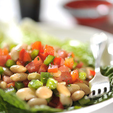 Colocar la lechuga picada en un platón, añadir la ensalada de alubias y rociar con el aderezo. Servir como plato fuerte vegetariano o como entrada.