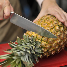 Pelar la piña con el cuchillo, cortar en rebanadas, retirar el centro fibroso de cada rebanada con un cuchillo. Cortar en trozos las rebanadas.