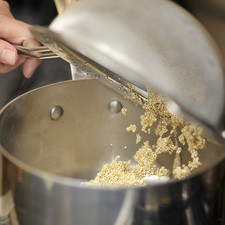 Colocar la quinoa en una olla honda con dos tazas de agua, el trozo de cebolla, un diente de ajo y media cucharita de sal.