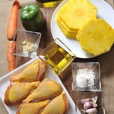 6 rebanadas de piña Pimienta blanca molida, al gusto Sal, al gusto 4 cucharadas de aceite de oliva 2 cucharadas de harina de trigo 4 dientes de ajo 1 pieza de chile morrón verde 1 botella de vino San Felipe Torrontés 2 piezas de zanahoria 6 piezas de pierna de pollo