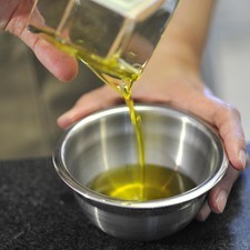 Preparar una vinagreta mezclando del aceite de oliva.