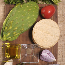 8 tostadas 6 pencas de nopal 1 cucharita de orégano seco 1 pizca de pimienta negra 1/4 de taza de aceite de oliva 1/4 de manojo de cilantro 2 chiles serranos 1 jitomate guaje 150 gramos de queso panela 1/4 de cebolla morada 1 pizca de bicarbonato Sal al gusto