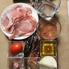 1 taza de agua 1 botella de vino tinto amado iv aceite de oliva al gusto 6 piezas de chuleta de cerdo pimienta negra molida al gusto sal al gusto 1 cucharada de manteca de puerco 1/2 taza de cocoa en polvo 50 gramos de piloncillo granulado 2 piezas de chile pasilla 2 piezas de chile guajillo 1 diente de ajo 1/4 pieza de cebolla blanca 1 pieza de jitomate guaje 1 cucharada de café molido