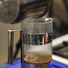 Para preparar el café, calentar el agua en una olla, agregar el agua caliente a una prensa francesa con el café, dejar reposar 3 minutos, aplastar la palanca y reservar.