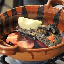 Agregar la cebolla, el ajo, los chiles desvenados y el piloncillo rallado. Sofreír durante 5 minutos, mezclando constantemente.