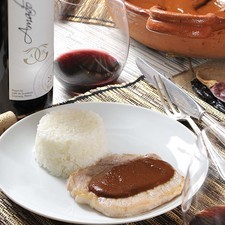 Servir las chuletas bañadas con el mole de café y cacao y acompañadas con puré de papa y una copa de vino Amado IV del Valle de Guadalupe en Ensenada.
