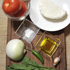 200 gramos de queso panela ½ cebolla 1 chile serrano 2 jitomates 1 diente de ajo 1 pizca de bicarbonato de sodio 1 ramita de epazote Sal al gusto Aceite de oliva