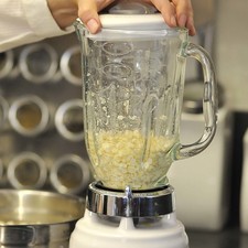 Desgranar los elotes con un cuchillo sobre la tabla para picar, cortando sólo dos filas a la vez. Una vez que se desgranó todo el elote repasar con el cuchillo para sacar toda la pulpa. Moler los granos de elote en la licuadora, moliendo partes a la vez para que se muelan bien. Si se tiene procesador de alimentos en más sencillo.