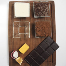 1/3 de taza de crema para batir 150 gramos chocolate semi-amargo para repostería 1/3 de barra de mantequilla (30 gramos) 50 gramos de granillo de chocolate 50 gramos de cocoa en polvo Capacillos de trufa 3 ml. de ron o brandy