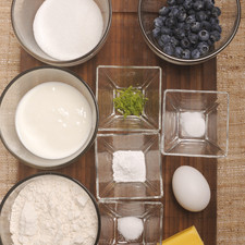 1 ½ tazas de harina de trigo 1 ½ cucharaditas de polvo para hornear ¼ cucharadita de bicarbonato de sodio ¼ cucharadita de sal 5 cucharadas de mantequilla ½ taza de azúcar 1 huevo ½ cucharadita ralladura de limón ¾ taza de yogur natural ¾ taza de moras azules 1 trozo de mantequilla