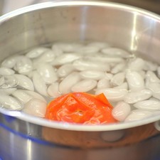 Colocar en un tazón con agua y hielo y dejar enfriar. Pelar y sacar las semillas.
