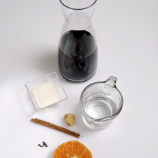 ¾ de taza de agua 1 vara de canela Pizca de jengibre 3 clavos ¼ de taza de azúcar blanca ½ naranja 1 botella de vino tinto, bueno